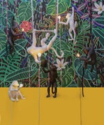 : Wall Lamp Monkey Hanging Black, shown mounted above a fireplace