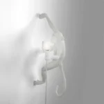 Wall Lamp Monkey Hanging White, shown mounted above a buffet