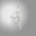 Wall Lamp Monkey Hanging White, shown mounted above a buffet