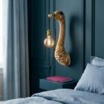 Wall Lamp Ostrich Gold Large, shown mounted in a living room
