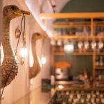 Wall Lamp Ostrich Gold Large, shown mounted in a living room
