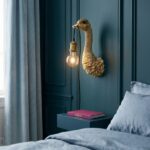 Wall Lamp Ostrich Gold, shown mounted on a small wall space