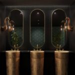 Wall Lamp Ostrich Gold, shown mounted on a small wall space