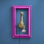 Wall Lamp Ostrich Gold, shown mounted on a small wall space