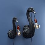 Wall Lamp Swan Black, shown mounted in a quiet corner