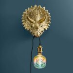 Wall Lamp Triceratops Gold, shown mounted in a living room