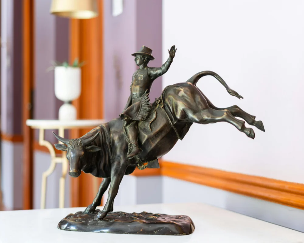 Bronze Western horse and rider sculpture displayed in a stylish interior