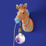 Wall Lamp Zebra Blue and Orange, illuminated view showing the visible bulb
