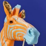 Wall Lamp Zebra Blue and Orange, illuminated view showing the visible bulb
