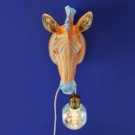Wall Lamp Zebra Blue and Orange, illuminated view showing the visible bulb